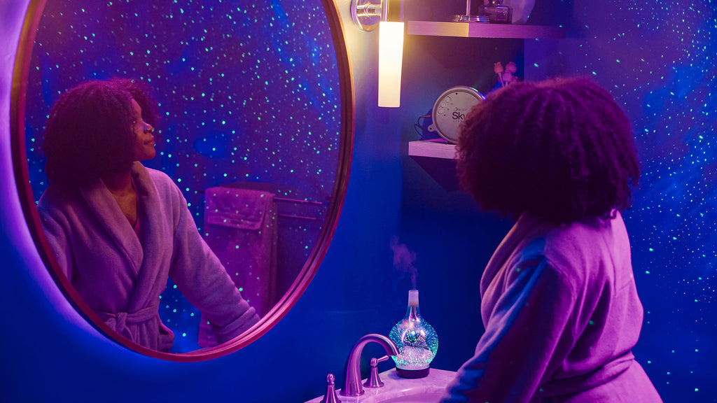 woman looking at reflection of galaxy lights in bathroom mirror