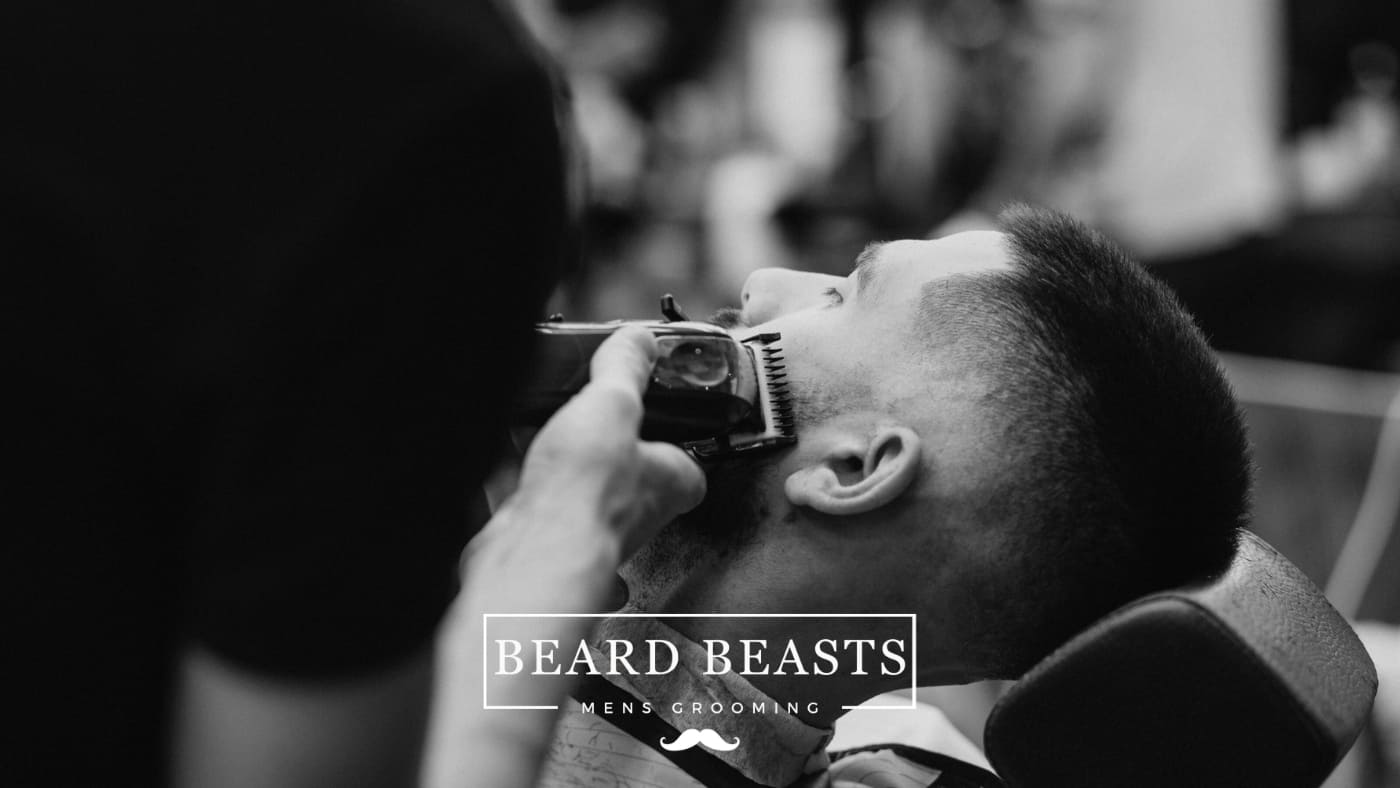 Barber carefully giving a man a 12mm haircut, showcasing precision grooming in a professional barbershop setting.