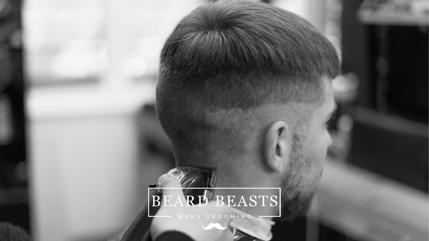 a man getting a fade haircut, representing the fade in the crew cut vs fade debate.