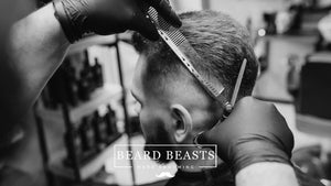 A man getting a haircut by a professional, representing regular grooming and the concept of how often should men get a haircut.