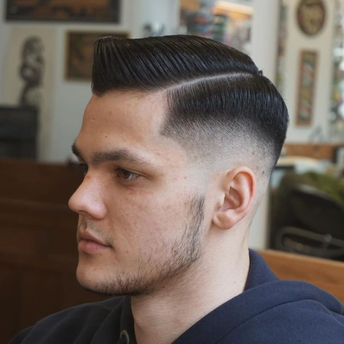 Side profile of a man with a stylish Side Part Quiff haircut featuring a sharp, defined side part and tapered fade. The sleek, voluminous quiff on top adds a modern, polished look.