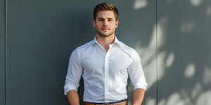 This image shows a stylish man in a crisp, well-fitted white button-down shirt, paired with a brown belt. The look highlights the importance of fit and simplicity in men's fashion, perfect for men's fashion tips for beginners. 