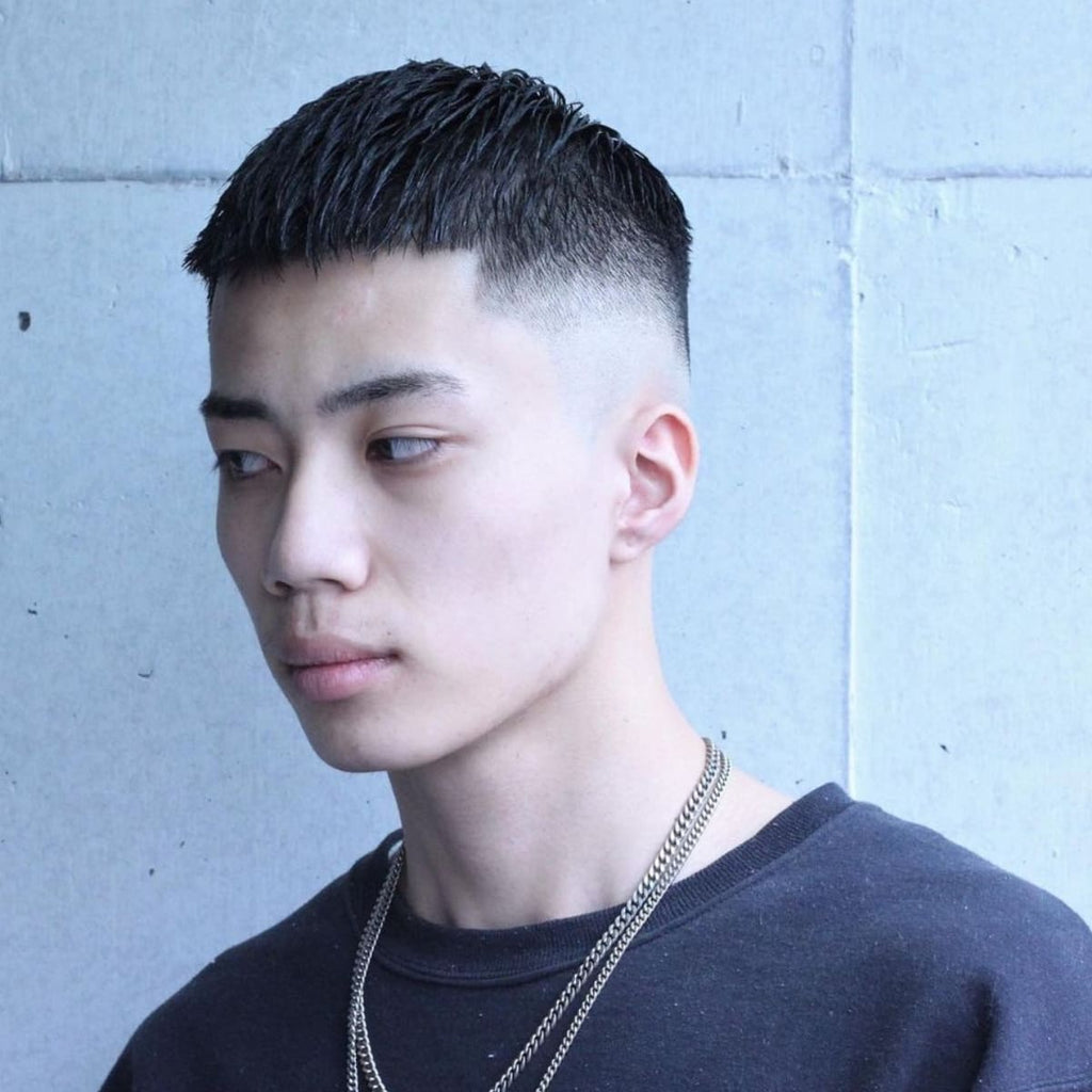 Side profile of a young man with a clean crew cut featuring a smooth fade. The haircut combines a short, textured top with a high fade down to the skin, creating a minimalist yet stylish look. This cut accentuates the jawline and adds structure to the face, ideal for a simple, modern style that’s easy to maintain.