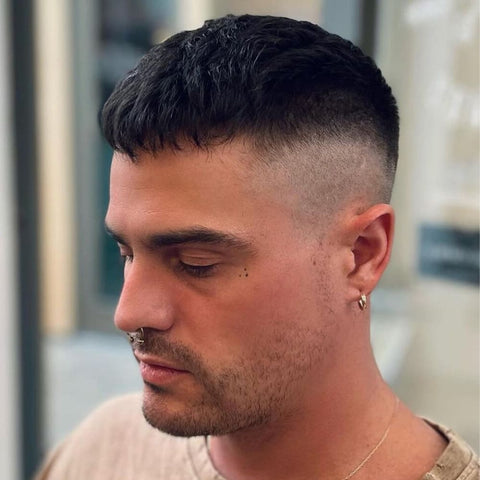 Man with a modern Caesar Cut, featuring a short, textured fringe and closely cropped sides. The clean fade enhances the sharp, defined lines of the haircut, giving it a contemporary edge. This short hairstyle for men is ideal for men seeking a low-maintenance yet stylish look.