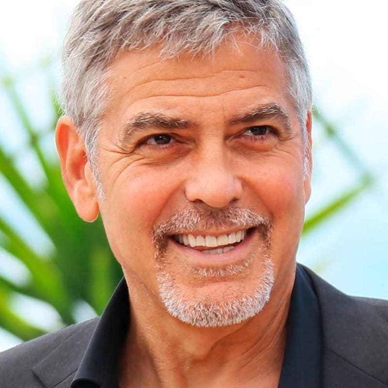 Smiling man with salt-and-pepper circle beard wearing a suit