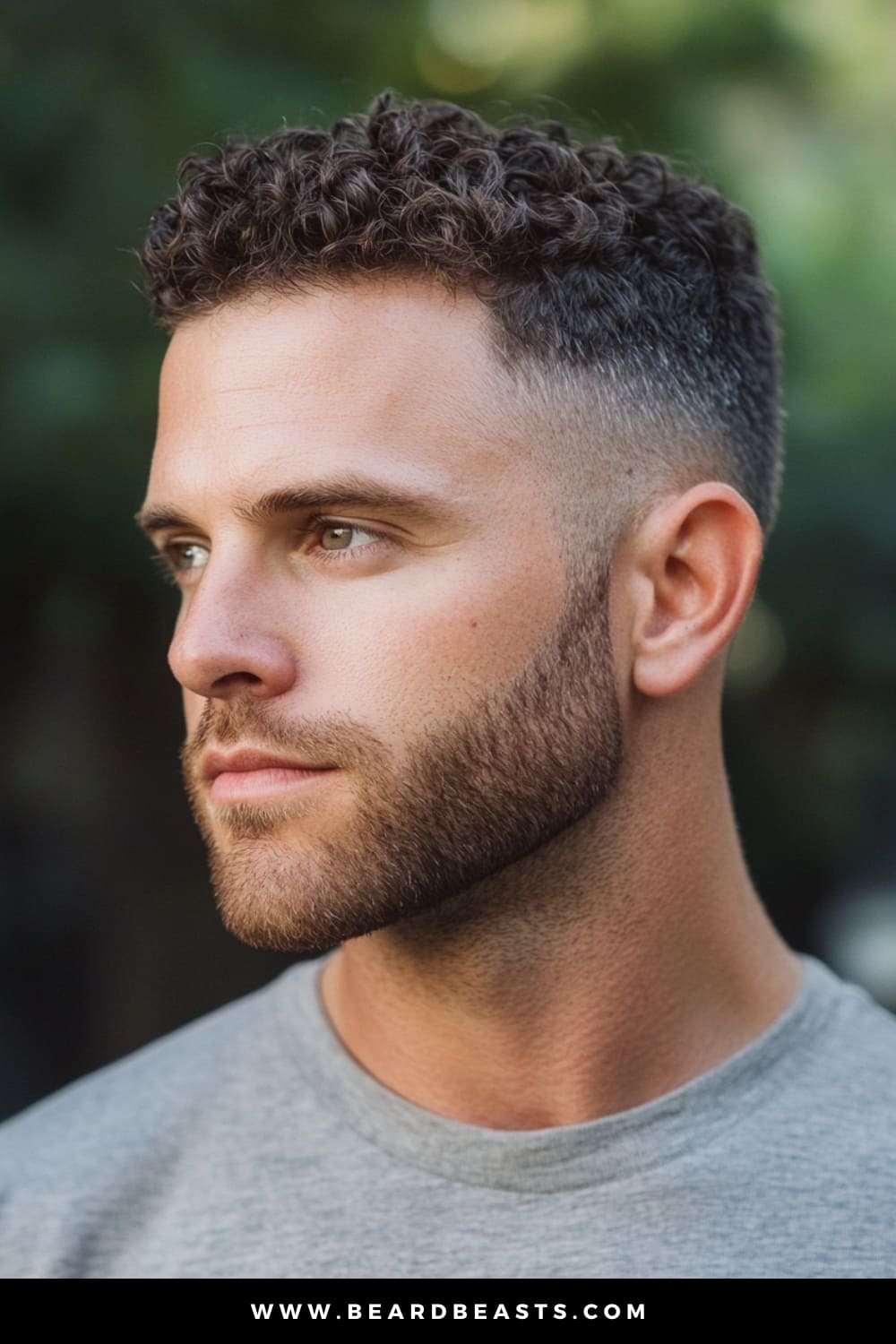 A man with a sharp curly temple fade haircut, featuring neatly trimmed sides that gradually blend into textured curls on top. His beard complements the fade, giving a clean yet stylish appearance. This curly hair fade is perfect for those looking for a modern, low-maintenance style that highlights natural curls. Ideal for showcasing a temple fade with curly hair.