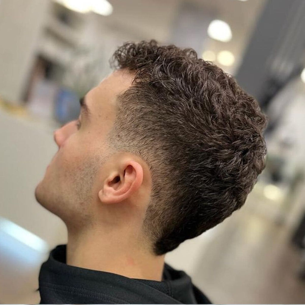 Side view of a haircut featuring a curly top paired with a clean blend. The blend transitions seamlessly from the skin near the ears to fuller curls on top, creating a balanced and stylish look. The natural curls add texture and volume, while the blend provides a sharp and modern edge. Ideal for a fresh, low-maintenance style that highlights natural hair texture.