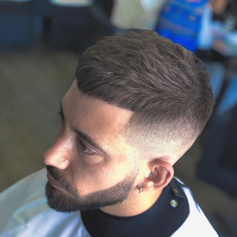 Man with a stylish French Crop haircut, featuring a short, textured top and a blunt fringe. The sides are faded seamlessly, creating a clean and modern look. This short hairstyle for men is perfect for men seeking a low-maintenance yet fashionable appearance, ideal for both casual and professional settings.