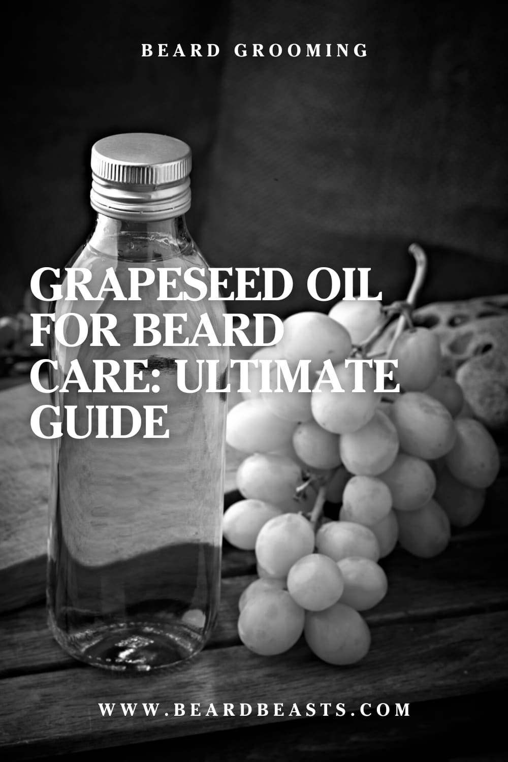 Glass bottle of grapeseed oil and bunch of grapes on wooden surface with text 'Grapeseed Oil for Beard Care: Ultimate Guide - www.beardbeasts.com' for beard grooming enthusiasts.