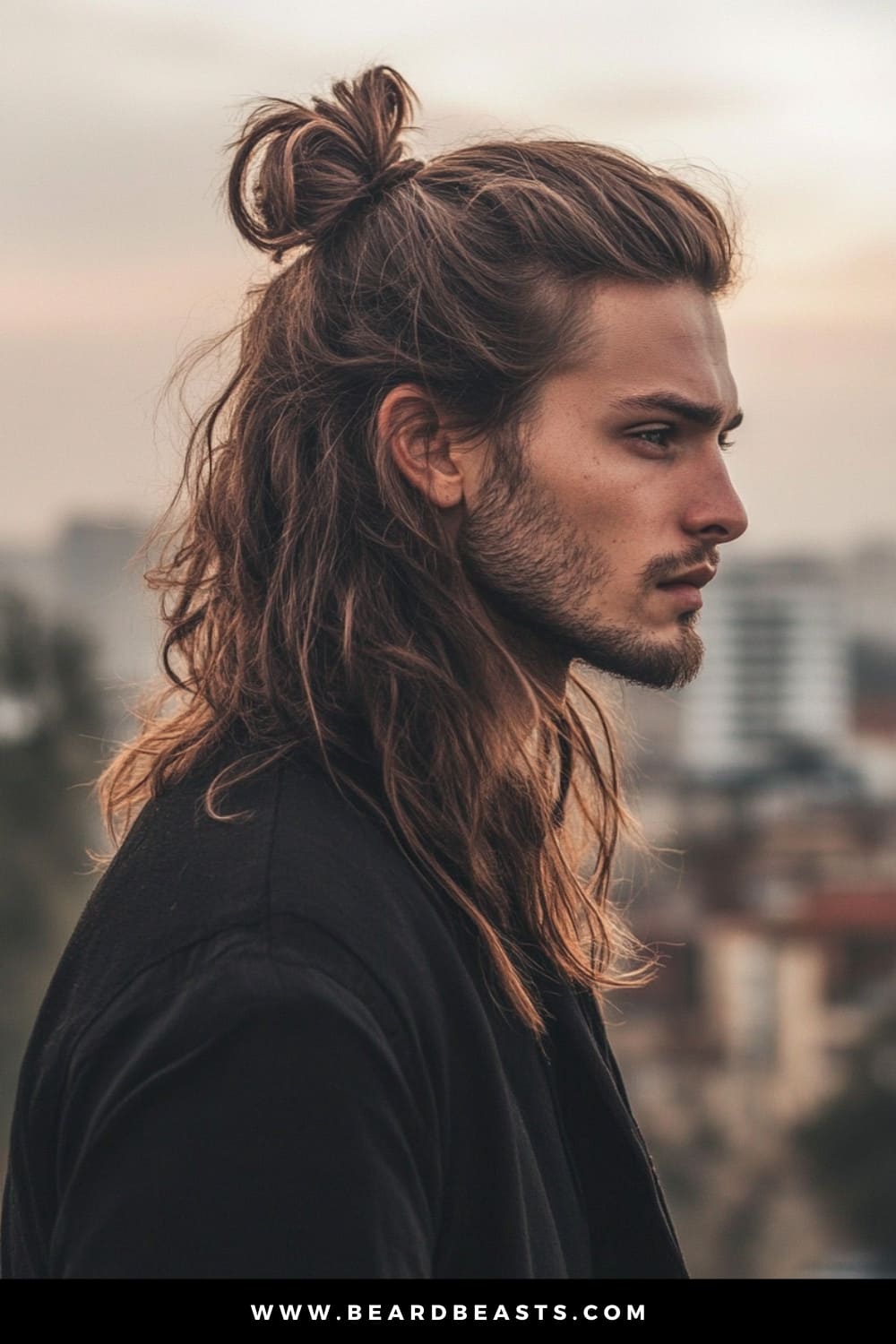Profile of a man with long, wavy hair styled in a half-up, half-down look, paired with a light beard. The relaxed, effortless style blends casual and bohemian vibes, making it a perfect example of men's hairstyles for long hair that is both trendy and versatile.