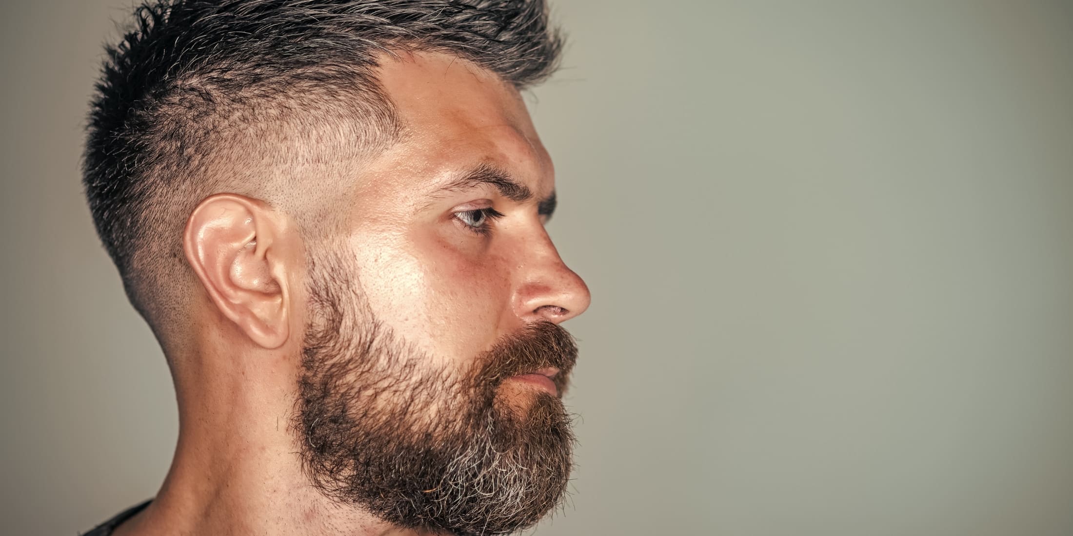 Side profile of a man with a high fade haircut, illustrating the fade vs taper differences.