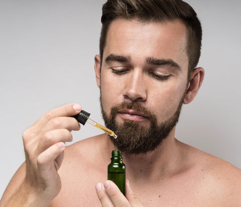 a bearded man using beard beasts sandalwood beard oil to soften his beard hair