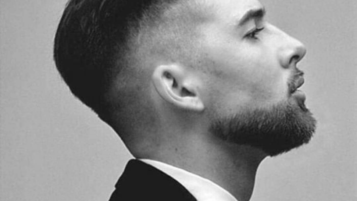 Side profile of a man sporting a sleek 20 mm beard with a tailored suit.