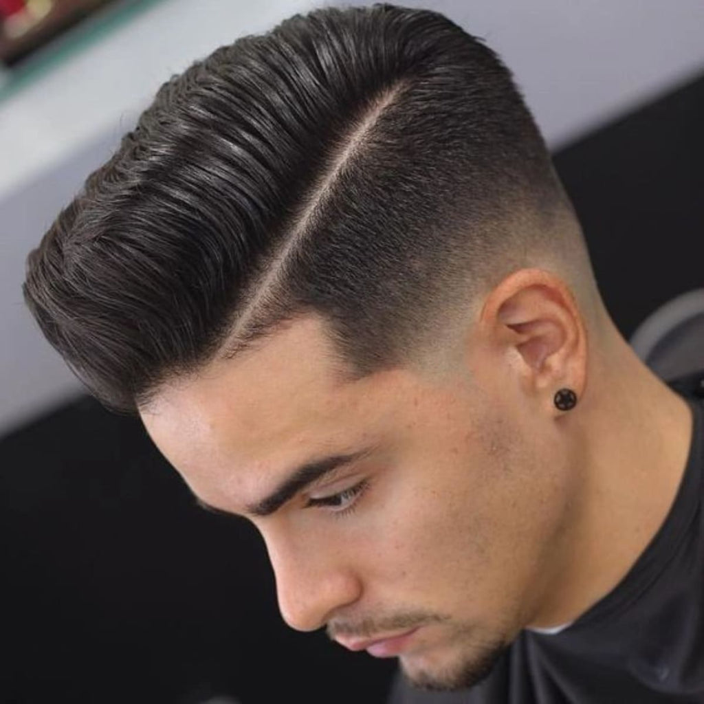 Side profile of a man with a sleek hairstyle featuring a defined side part, voluminous top, and a smooth transition on the sides.