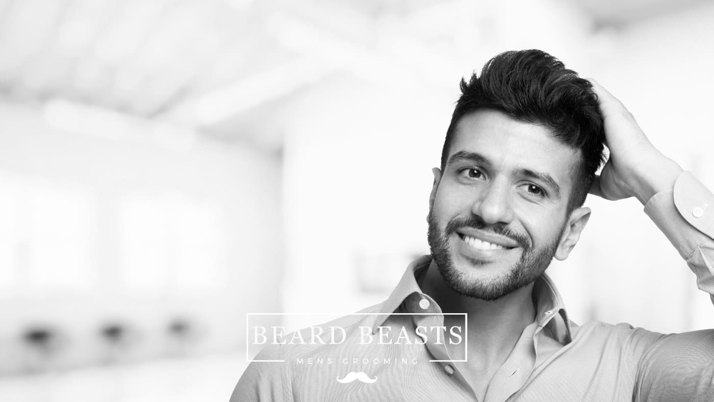 A smiling man with a stylish quiff haircut posing confidently, embodying the modern take on men's grooming, highlighting the trendy debate of pompadour vs quiff hairstyles.