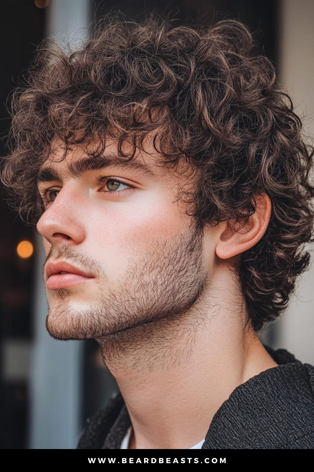 A young man showcasing a voluminous curly shag haircut, one of the most popular layered haircuts for men with curly hair. His naturally curly locks are enhanced with layers, adding definition and bounce to the overall style. The curls frame his face effortlessly, while the layers help reduce bulk, creating a balanced and stylish look. Paired with a soft, subtle stubble and a casual outfit, his appearance is relaxed yet stylish, perfectly highlighting the textured charm of his layered curls.