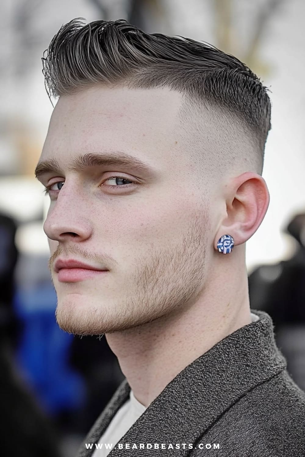 Man wearing a high and tight fade hairstyle, with the sides closely shaved and a slightly longer length on top styled upward for a clean, structured look. This military-inspired cut is sharp and polished, making it a perfect choice for formal events. Paired with subtle facial hair and a formal jacket, this hairstyle exemplifies classic and contemporary men's formal hairstyles, ideal for a sleek, confident appearance.