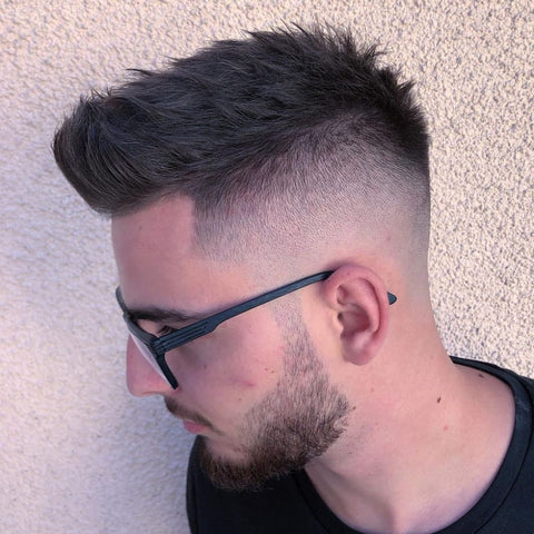 Side view of a man with a modern quiff hairstyle, featuring textured hair on top and a clean fade on the sides. This classic men's hairstyle combines volume and structure, offering a stylish and contemporary look perfect for those who want to stand out while maintaining a timeless appeal.