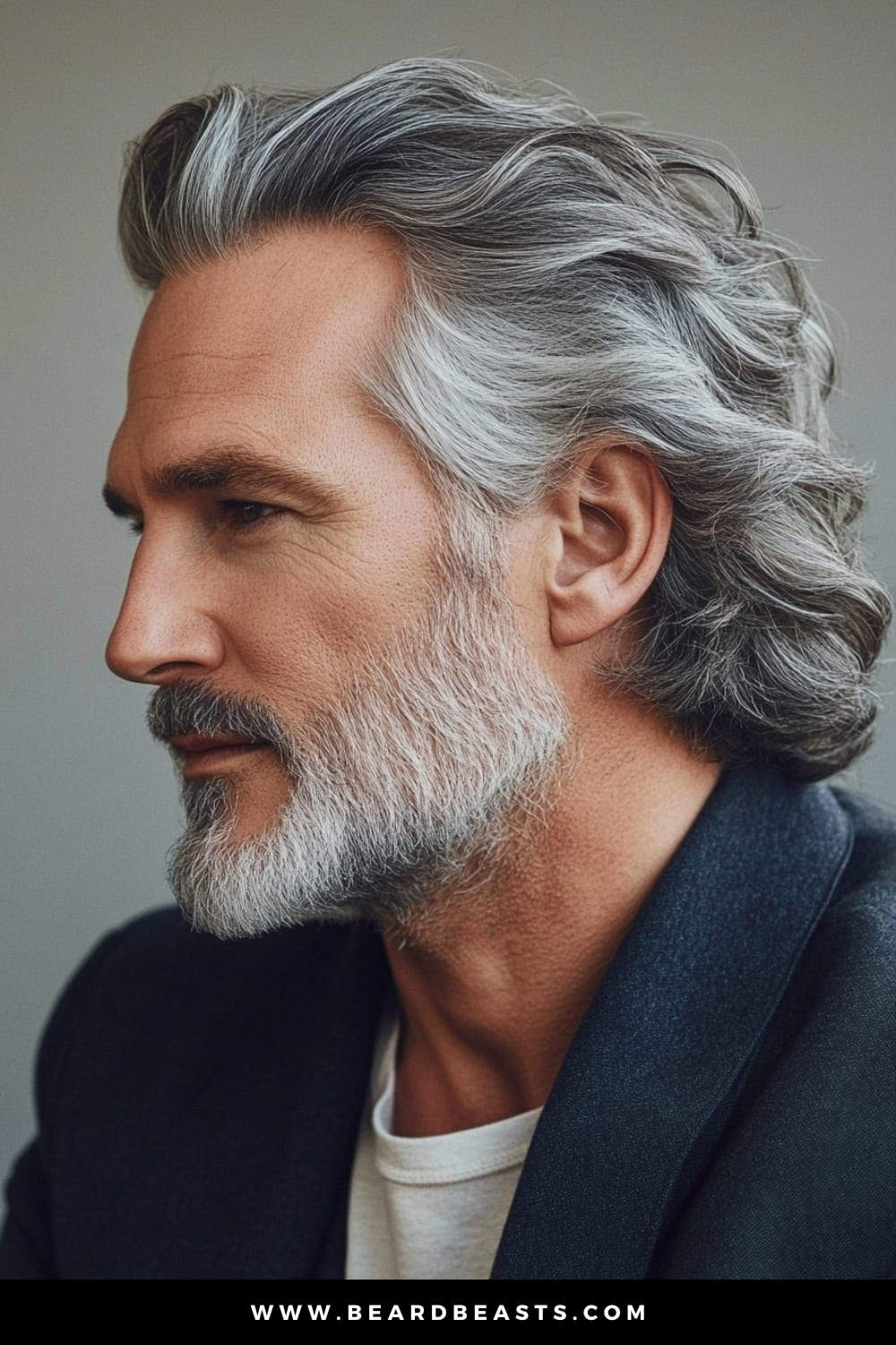 A distinguished older man with a full beard, showcasing long, silver hair, an elegant example of long hairstyles for older men. His hair is styled back with a natural wave, highlighting the rich silver tones and adding a sense of sophistication and confidence. The combination of the flowing hair and well-groomed beard creates a timeless look that exudes maturity and grace. This image captures the refined beauty of embracing natural gray hair, perfect for men who want to maintain a stylish and distinguished appearance.