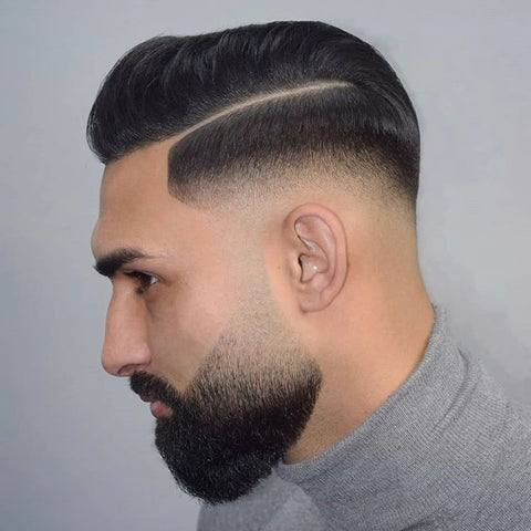 Close-up of a man with a sharp side part hairstyle featuring a clean fade and well-groomed beard. This classic men's hairstyle combines modern precision with timeless elegance, ideal for a sophisticated, polished look.