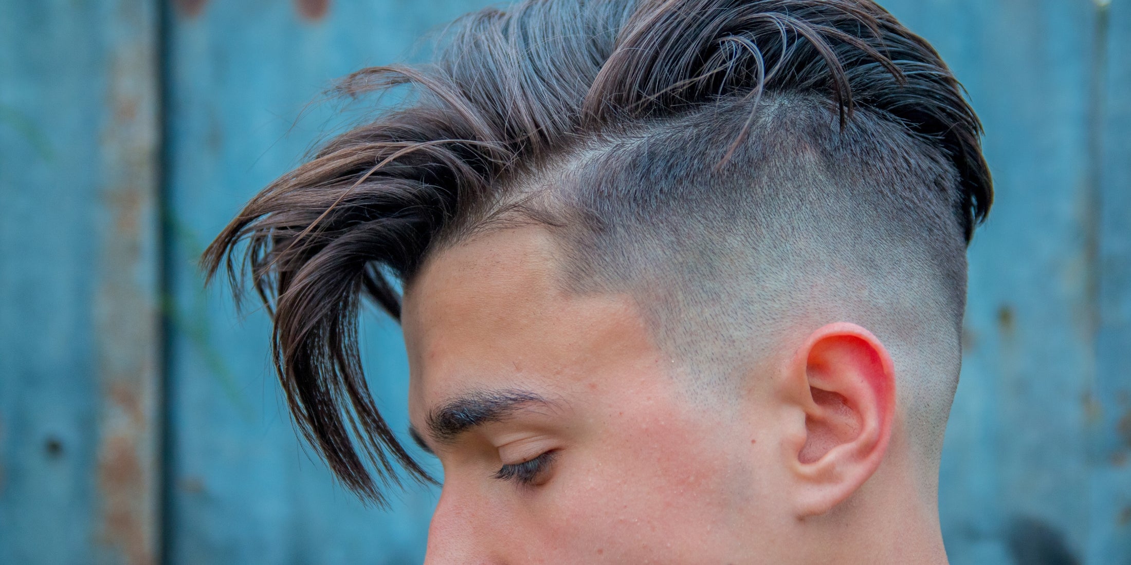 Close-up of a man with a trendy disconnected undercut hairstyle, highlighting how to ask for an undercut at the barber for a stylish look.