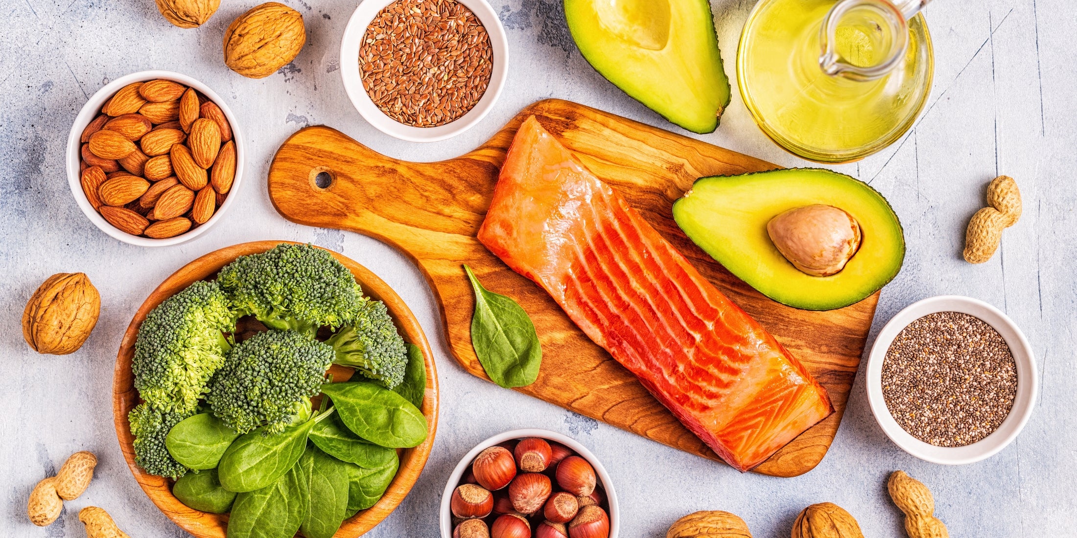 Selection of nutrient-dense foods including salmon, avocado, broccoli, spinach, almonds, walnuts, flax seeds, and chia seeds, highlighting key vitamins and minerals that promote beard growth and support overall health.