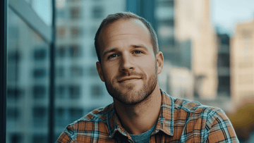 A man with a crew cut, a popular choice among Men’s Hairstyles for Receding Hairlines, smiles softly while looking at the camera, showcasing a simple and stylish look.