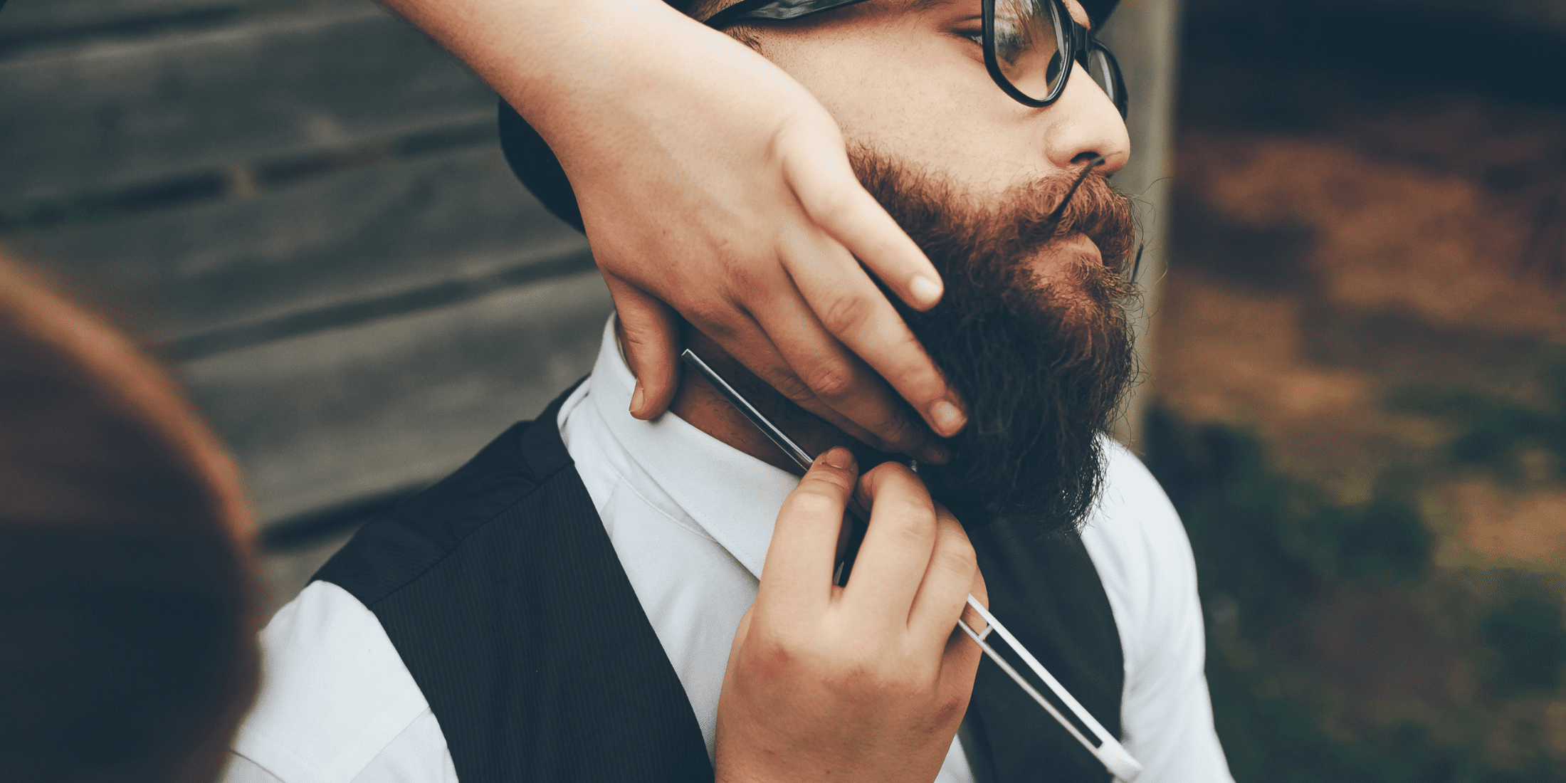 Barber carefully shaving a man's neck with a straight razor, emphasizing precision and traditional shaving techniques. Discover how to shave with a straight razor for a professional, smooth finish.