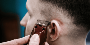 Close-up of a man getting a precise haircut with clean clippers. Learn how to clean clipper blades for top-notch grooming results and hygiene.