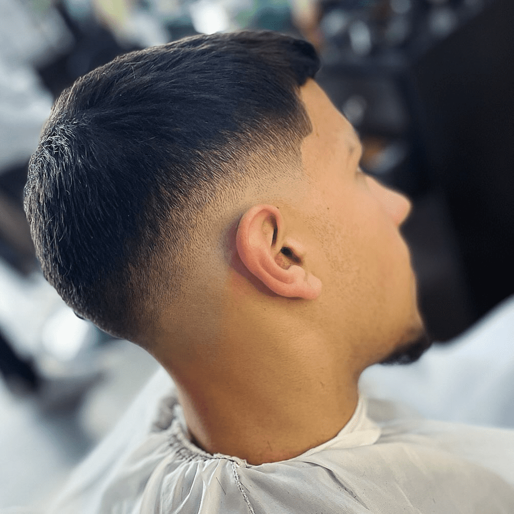 Close-up of a stylish drop fade haircut with a smooth transition and natural contour around the ear. Ideal for oval, heart, and long face shapes. Learn more about the differences between burst fade vs drop fade in our detailed guide.