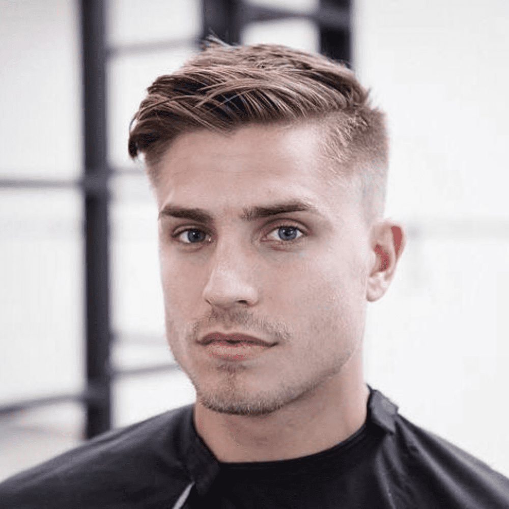 Front view of a man with a Fade Undercut hairstyle, featuring longer, textured hair on top that is styled to the side, combined with a clean fade on the sides and back. This hairstyle offers a modern and edgy look, perfect for men seeking stylish fade hairstyle