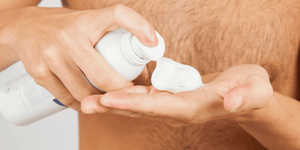 A close-up of a man applying shaving cream to his hand, illustrating the process and benefits. This image helps answer the question, What does shaving cream do? by showing its application for a smoother shave.