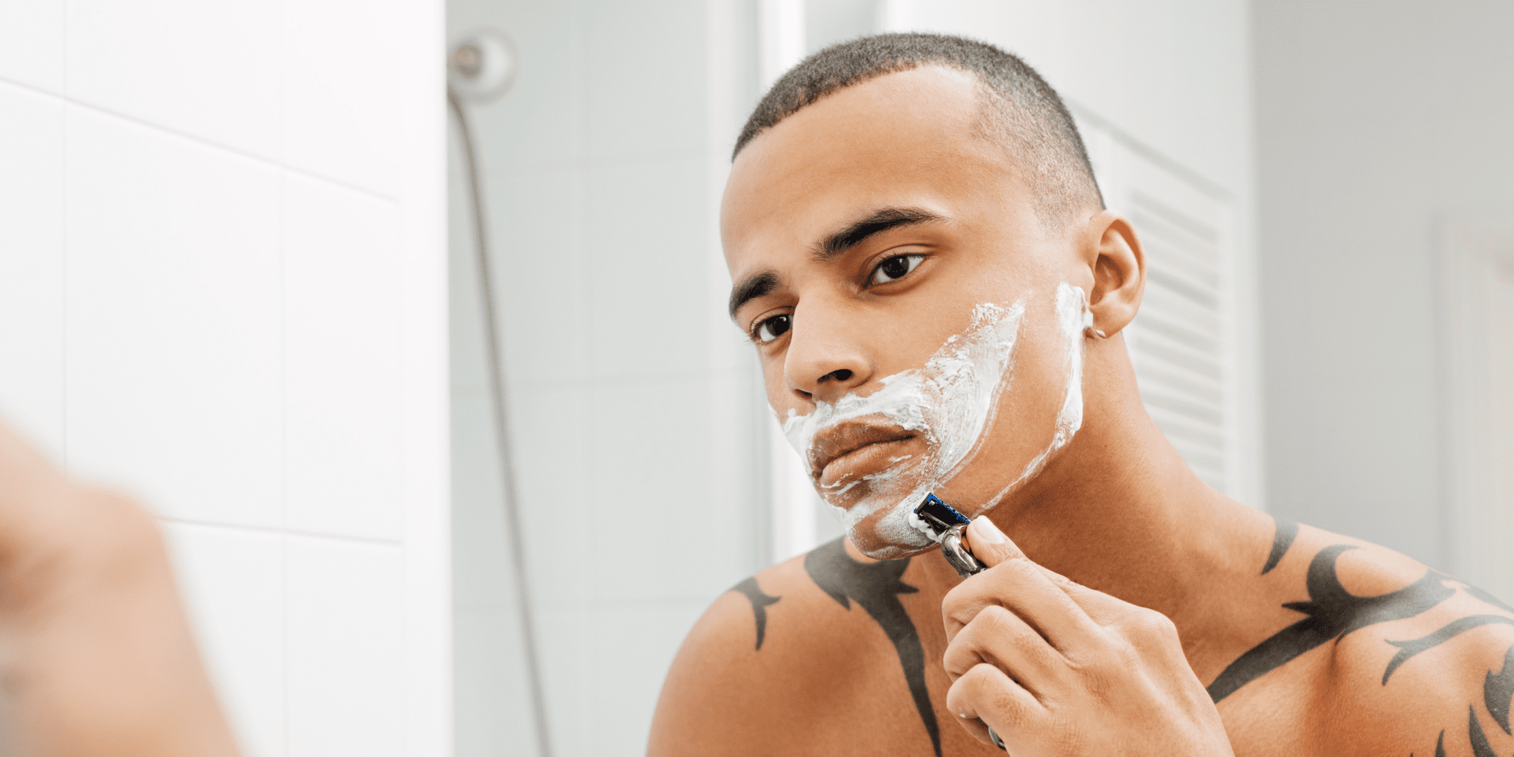 Man shaving in front of a mirror using shaving soap, demonstrating how to use shaving soap for a smooth and comfortable shave.