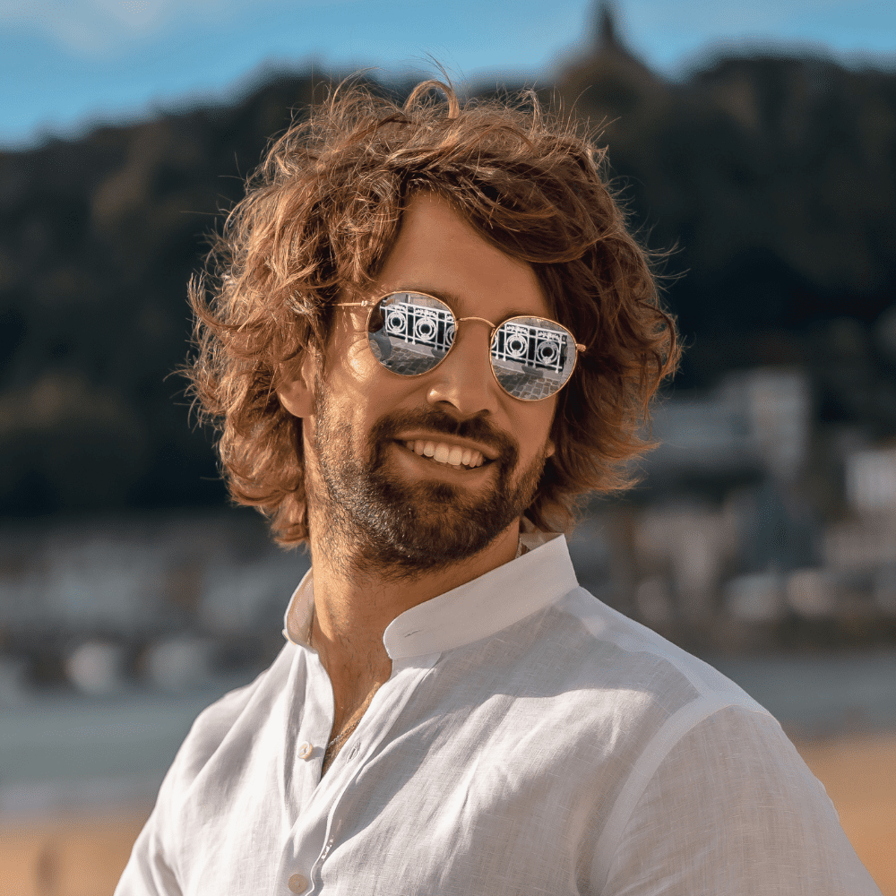 This image features a stylish Messy Curls haircut for men, showcasing natural, medium-length curls with a relaxed, tousled look. Perfect for a casual and laid-back vibe, this hairstyle emphasizes the natural texture and movement of curly hair. Ideal for men who prefer a low-maintenance yet trendy appearance, the messy curls offer a versatile look that suits various face shapes. This haircut is a popular choice for 2024, combining effortless style with the natural beauty of curls.