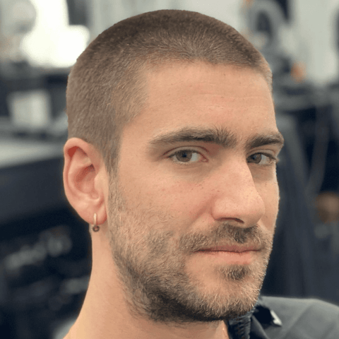 Close-up of a man with a number 3 buzz cut, showcasing the clean and uniform 3/8 inch length. The hairstyle emphasizes his facial features and complements his light stubble, highlighting a modern, low-maintenance look suitable for various face shapes and hair types.