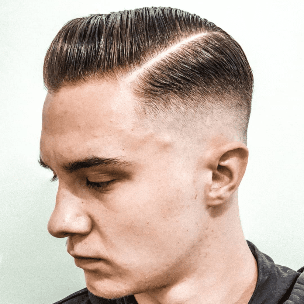 Side profile of a man with a Side Part Razor Fade haircut, featuring a neatly combed side part with a hard razor line and a clean fade on the sides and back. The hairstyle highlights a polished and sophisticated look, making it an ideal choice for men seeking stylish and professional fade haircuts.